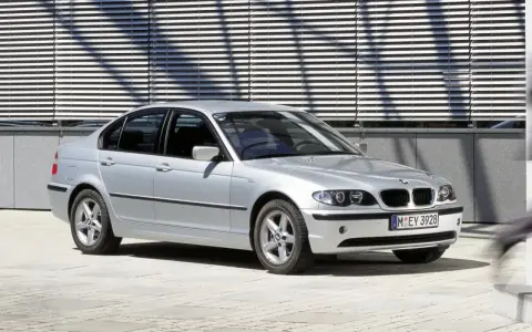 Srebrne e46 bmw sedan stoi przed nowoczesnym budynkiem z żaluzjami.