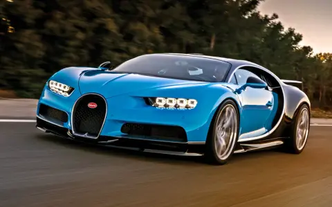 Niebieski Bugatti Chiron pędzi po drodze, budząc podziw mocą 1500 koni mechanicznych.