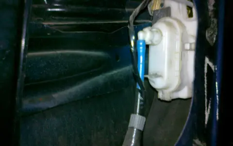 Mechanizm zamka w drzwiach VW Polo. Widoczny siłownik i przewody, pomocne przy pytaniu jak zamontować centralny zamek VW Polo.