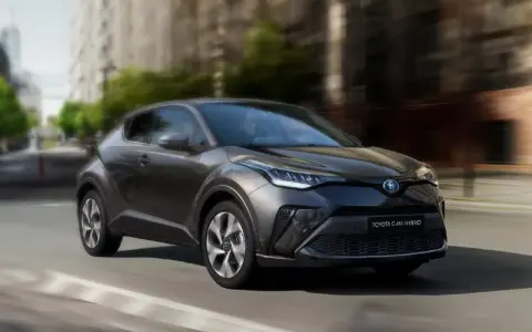 Ciemnoszara Toyota C-HR Hybrid w ruchu miejskim. Zastanawiasz się, ile pali Toyota C-HR Hybrid? Ten stylowy crossover zachwyca niskim spalaniem.