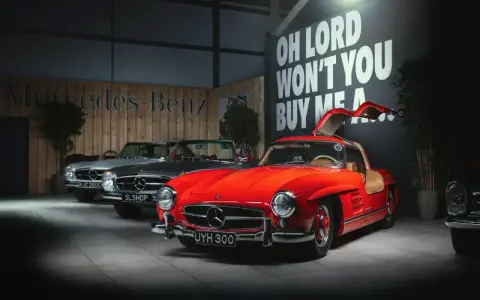 Czerwony Mercedes 300 z drzwiami skrzydłowymi, obok srebrny i szary model.