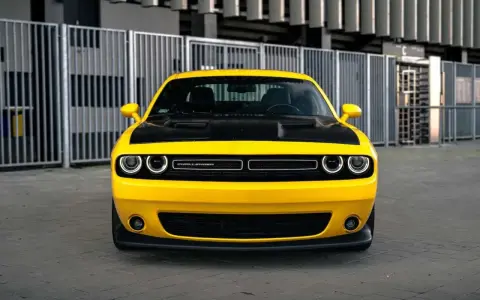 Żółty Dodge Challenger z czarną maską, gotowy do jazdy. Sprawdź jego atrakcyjną dodge challenger cena!