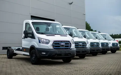 Rząd białych Fordów Transit, gotowych do pracy. Zastanawiasz się, ile waży bus dostawczy? Te modele czekają na zabudowę.