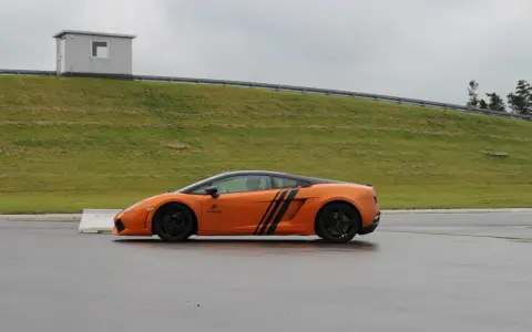 Pomarańczowe Lamborghini na torze. Zastanawiasz się, ile kosztuje przejazd takim autem?