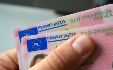 Dłoń trzyma polskie prawa jazdy. Widoczne napisy "PRAWO JAZDY" i "RZECZPOSPOLITA POLSKA" sugerują różne kategorie prawa jazdy.