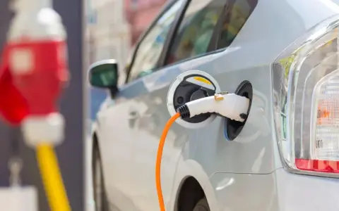 Samochód elektryczny podłączony do ładowarki. Zastanawiasz się, co ile trzeba ładować samochód elektryczny? To zależy od wielu czynników, ale zazwyczaj raz na kilka dni.