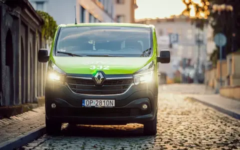 Zielony bus GTV BUS 332 na brukowanej ulicy. Sprawdź, ile kosztuje bus z adresu pod adres.