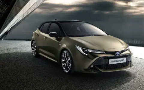 Nowy Toyota Auris Hybrid, stylowy następca Priusa, prezentuje się dynamicznie na tle nowoczesnej architektury.