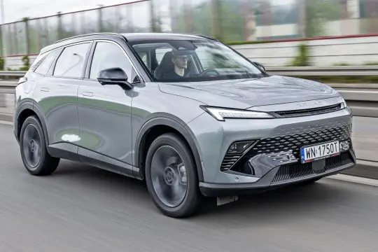 Szary SUV Beijing 5 jedzie po drodze. Kierowca w okularach prowadzi auto.