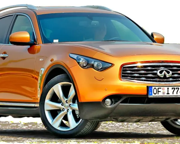 Pomarańczowy infiniti samochód z chromowanymi detalami i felgami, gotowy na przygodę.
