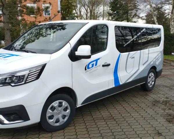 Biały bus Galaxy-Trans z logo GT. Zapytaj, ile kosztuje bus do Holandii, by poznać ceny przejazdów.