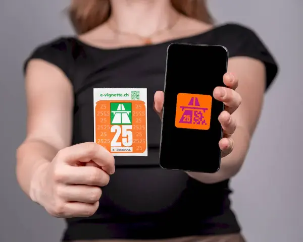 Kobieta trzyma w dłoniach winietę szwajcaria i smartfon z aplikacją.