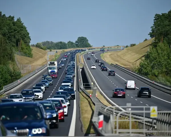 Korek na autostradzie bursztynowej. Długi sznur samochodów i ciężarówek sunie powoli w upalny dzień.