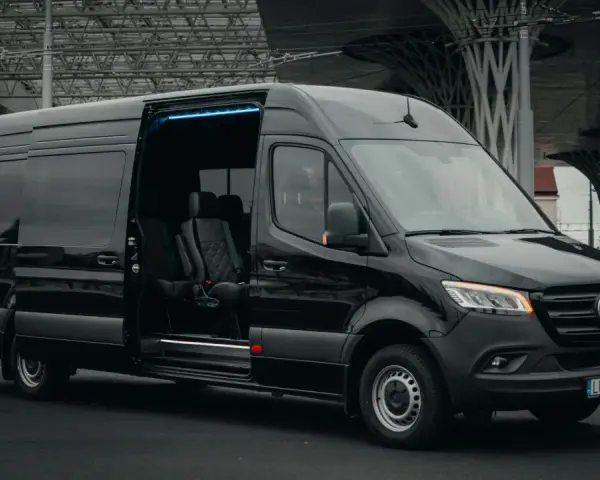 Czarny Mercedes Sprinter z otwartymi drzwiami, wnętrze z wygodnymi fotelami. Zastanawiasz się, ile kosztuje bus do Francji?