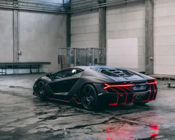 Czarny Lamborghini Centenario z czerwonymi akcentami, stojący w garażu. Zastanawiasz się, ile kosztuje Lamborghini Centenario?