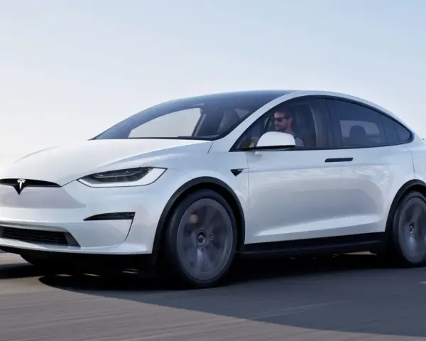 Biała Tesla Model X jedzie po drodze. Zastanawiasz się, ile kosztuje Tesla Model X?