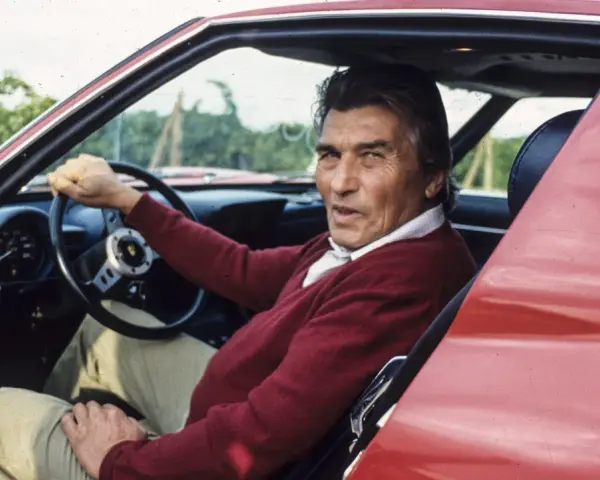 Ferruccio Lamborghini, kto stworzył Lamborghini, siedzi za kierownicą swojego czerwonego supersamochodu.