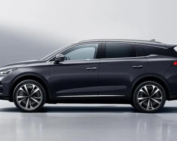 Ciemnoszary BYD Tang, SUV z eleganckimi felgami, prezentuje się na tle jasnej ściany. Sprawdź byd tang cena i jego możliwości.