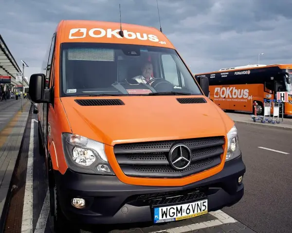 Pomarańczowy bus OKBUS czeka na pasażerów. Zastanawiasz się, ile kosztuje bus z Łodzi do Uniejowa? Sprawdź ofertę przewoźnika.