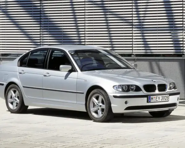 Srebrne e46 bmw sedan stoi przed nowoczesnym budynkiem z żaluzjami.