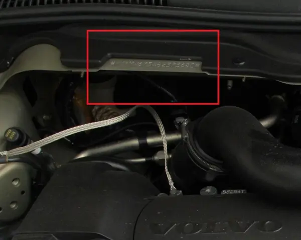 Widoczny numer nadwozia wybity na metalowej płytce w komorze silnika Volvo.