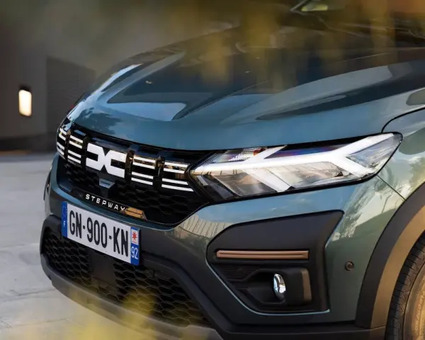 Nowy Dacia Sandero Stepway w zielonym kolorze, z charakterystycznym logo i nowoczesnymi światłami LED.