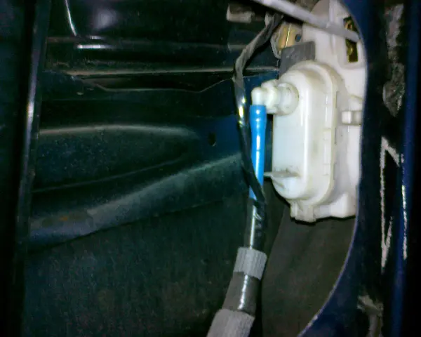 Mechanizm zamka w drzwiach VW Polo. Widoczny siłownik i przewody, pomocne przy pytaniu jak zamontować centralny zamek VW Polo.
