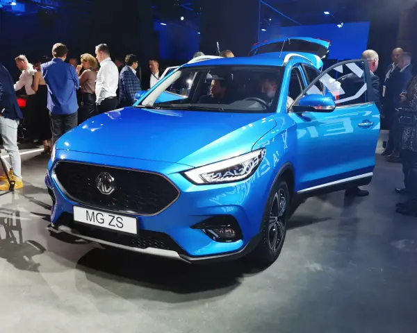 Błękitny MG ZS na prezentacji. Ludzie oglądają nowy model marki MG.
