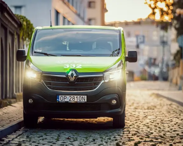 Zielony bus GTV BUS 332 na brukowanej ulicy. Sprawdź, ile kosztuje bus z adresu pod adres.