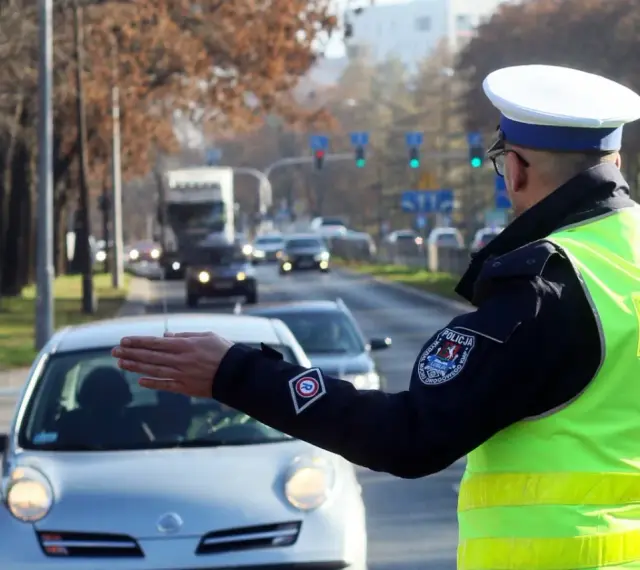 Policjant kieruje ruchem na ulicy. Kierowca zatrzymuje się, bo zgubił prawo jazdy i boi się kontroli.