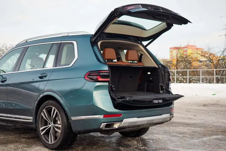 Zielony BMW X7 z otwartym bagażnikiem, idealny na rodzinne wyjazdy. Sprawdź aktualną bmw x7 cena.