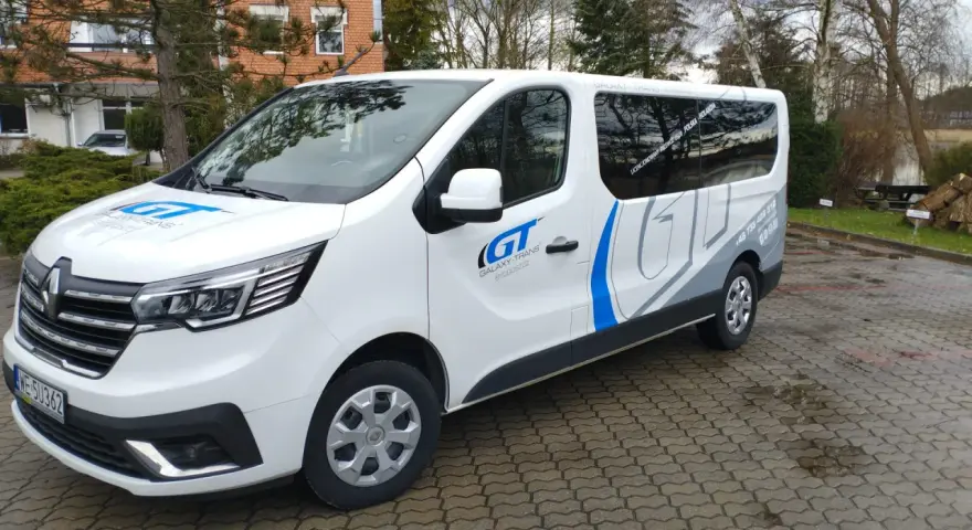 Biały bus Galaxy-Trans z logo GT. Zapytaj, ile kosztuje bus do Holandii, by poznać ceny przejazdów.