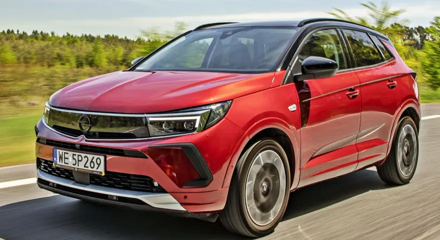 Czerwony Opel Grandland na drodze, idealny do sprawdzenia jego opel grandland cena.
