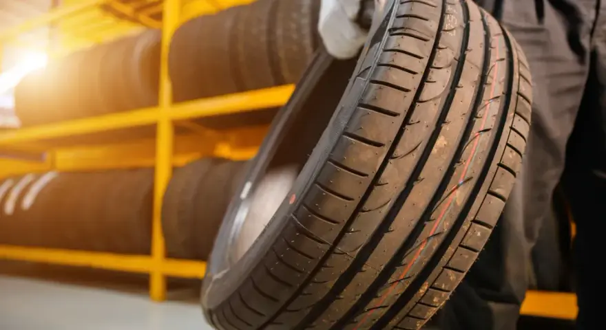 Nowe opony na żółtej półce. Czy koło zapasowe jest obowiązkowe? Warto mieć zapas, gdy coś się stanie.
