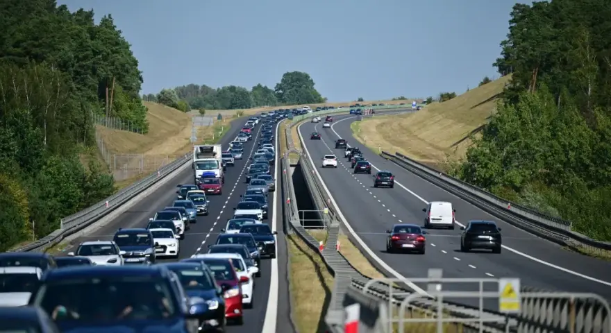 Korek na autostradzie bursztynowej. Długi sznur samochodów i ciężarówek sunie powoli w upalny dzień.