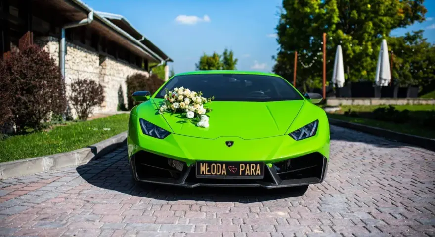 Jaskrawozielone Lamborghini Huracan z bukietem kwiatów na masce i napisem "Młoda Para". Zastanawiasz się, ile kosztuje Lamborghini Huracan?