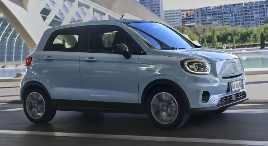 Jasnoszary Leapmotor T03 na tle nowoczesnej architektury. Sprawdź, jaka jest leapmotor t03 cena i czy to auto dla Ciebie.