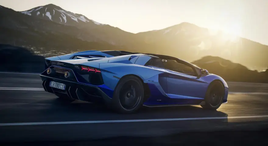 Niebieski Lamborghini Aventador pędzi po górskiej drodze. Choć trudno określić, ile pali Lamborghini Aventador, jego moc jest niezaprzeczalna.