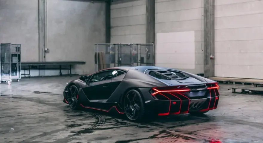 Czarny Lamborghini Centenario z czerwonymi akcentami, stojący w garażu. Zastanawiasz się, ile kosztuje Lamborghini Centenario?