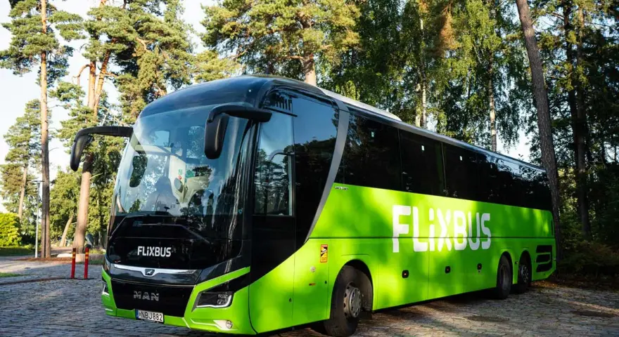Zielony polski bus FlixBus stoi na brukowanym placu. Zastanawiasz się, jak oddać bilet?