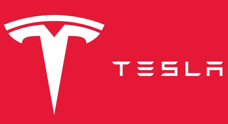 Biały, stylizowany symbol litery "T" i napis "TESLA" na czerwonym tle. Tak wygląda znaczek Tesli.