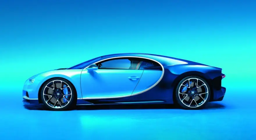 Błękitno-granatowe Bugatti Chiron widziane z boku na tle błękitnego gradientu.