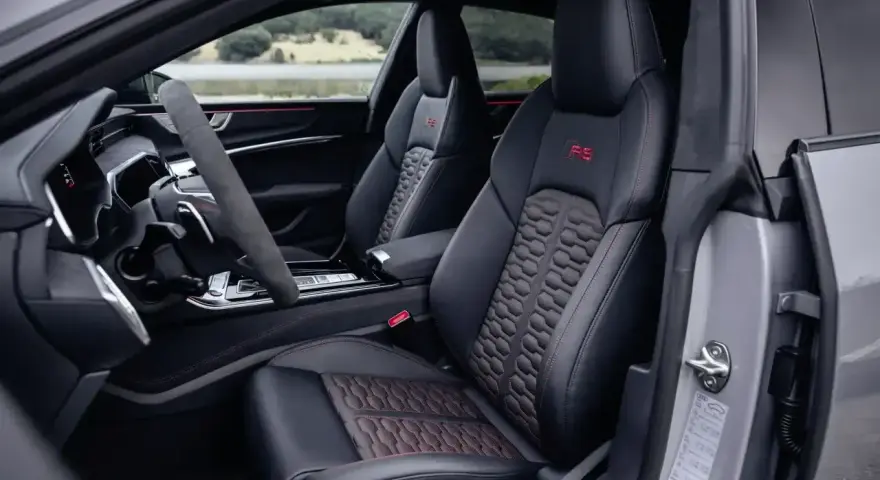 Wnętrze Audi RS7 z czerwonymi akcentami i sportowymi fotelami. Zastanawiasz się nad audi rs7 cena?