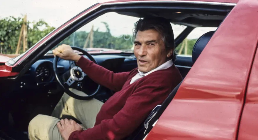 Ferruccio Lamborghini, kto stworzył Lamborghini, siedzi za kierownicą swojego czerwonego supersamochodu.