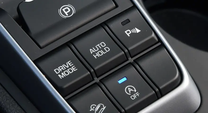 Przyciski w samochodzie: hamulec postojowy, Drive Mode, Auto Hold, asystent parkowania i kontrola zjazdu ze wzniesienia. Hill holder ułatwia ruszanie pod górę.