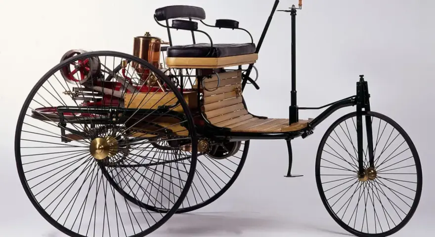 Tricykl Benz Patent-Motorwagen, pierwszy samochód na świecie, z drewnianym siedzeniem i miedzianym kotłem.