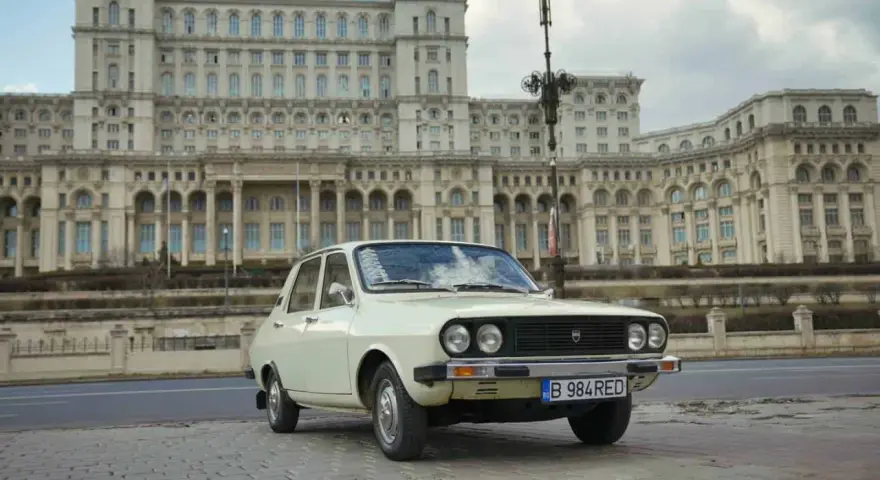 Biała Dacia 1300 na tle monumentalnego Pałacu Parlamentu w Bukareszcie.