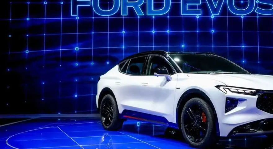 Biały Ford Evos na niebieskim, futurystycznym tle z siatką. Elegancka linia nadwozia i sportowe detale podkreślają jego nowoczesny charakter.