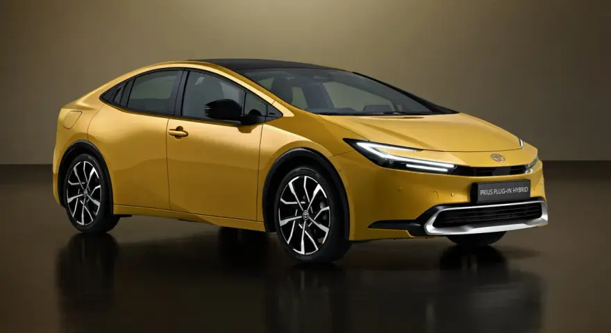 Złoty Toyota Prius Plug-in Hybrid, kiedy nowy prius w polsce, prezentuje się nowocześnie z czarnym dachem i eleganckimi felgami.