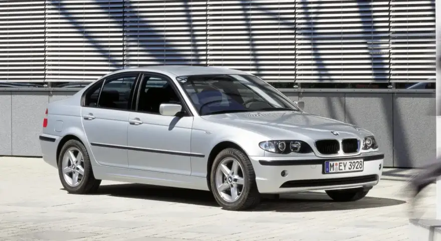 Srebrne e46 bmw sedan stoi przed nowoczesnym budynkiem z żaluzjami.
